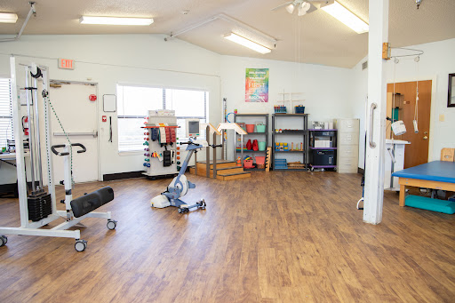 A well-equipped rehabilitation exercise room featuring various fitness tools and a spacious layout.