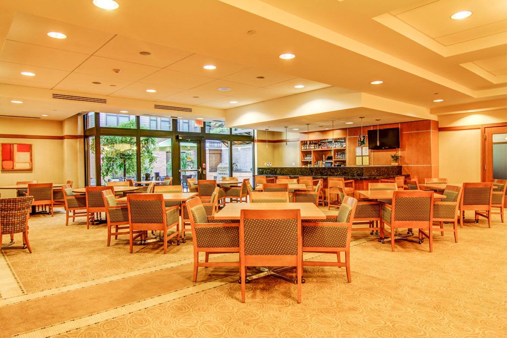 A warm and inviting dining area with tables, chairs, and a bar.