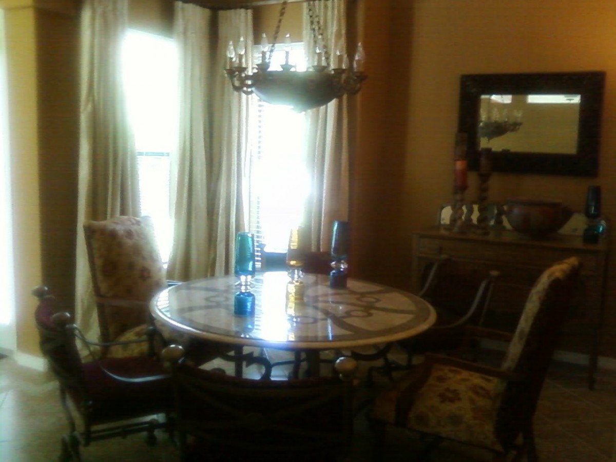 A cozy dining room with a round table and chandelier.