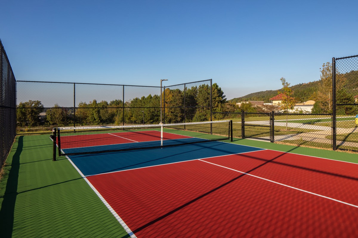 An empty outdoor sports court under a clear blue sky.