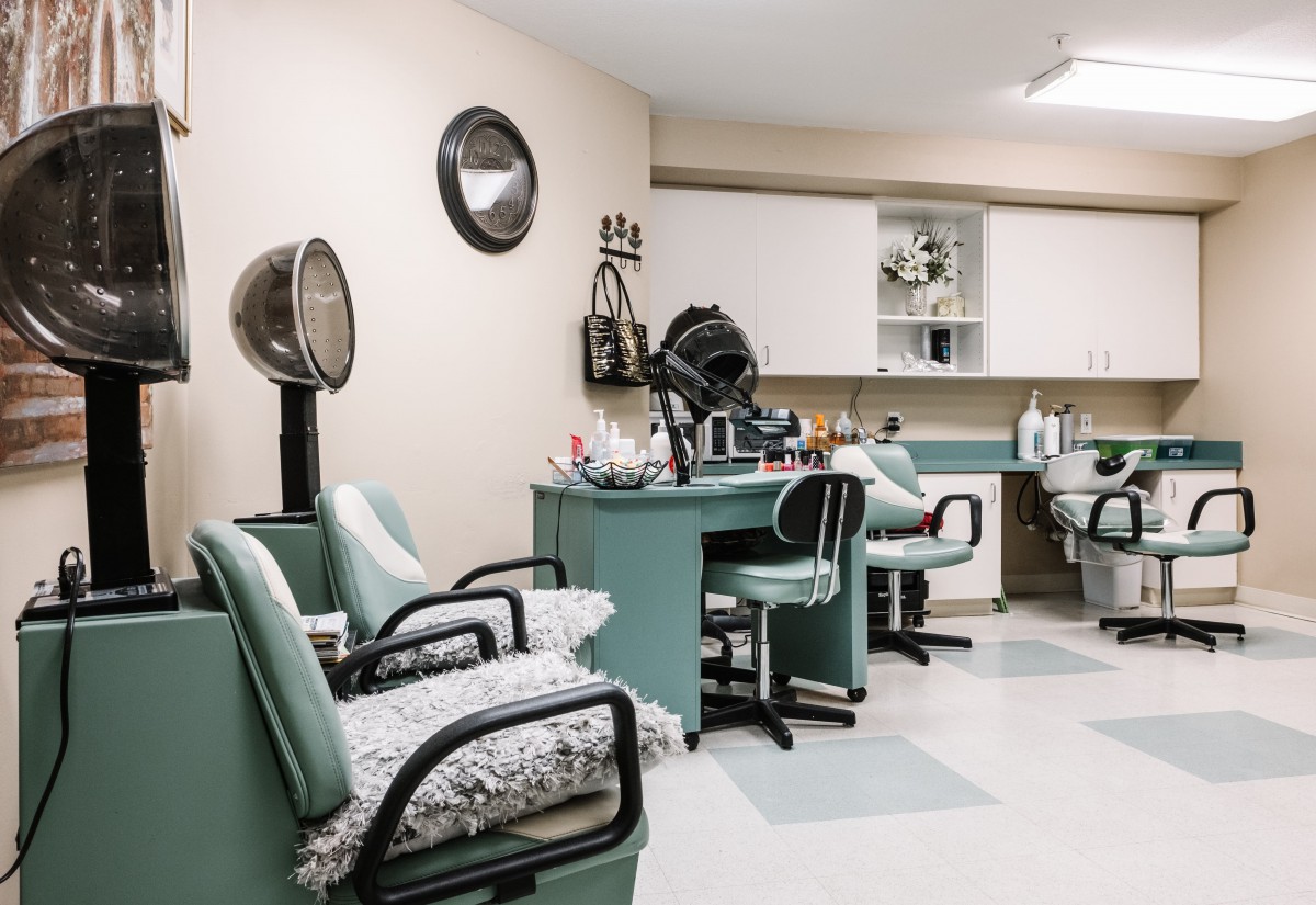 A well-organized beauty salon featuring chairs, mirrors, and hair dryers.