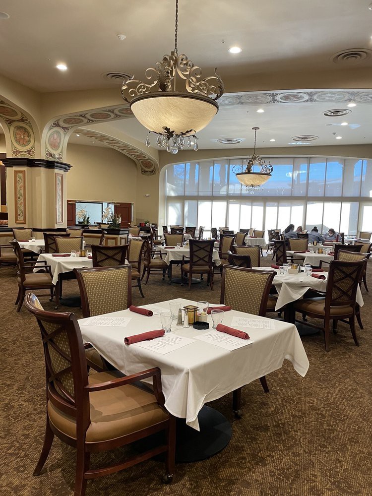 An elegant dining area with neatly arranged tables and chandeliers.
