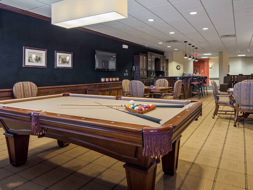 A cozy recreation room featuring a billiards table and bar area.