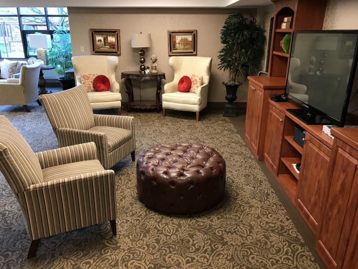 A cozy living room with comfortable chairs and an ottoman.