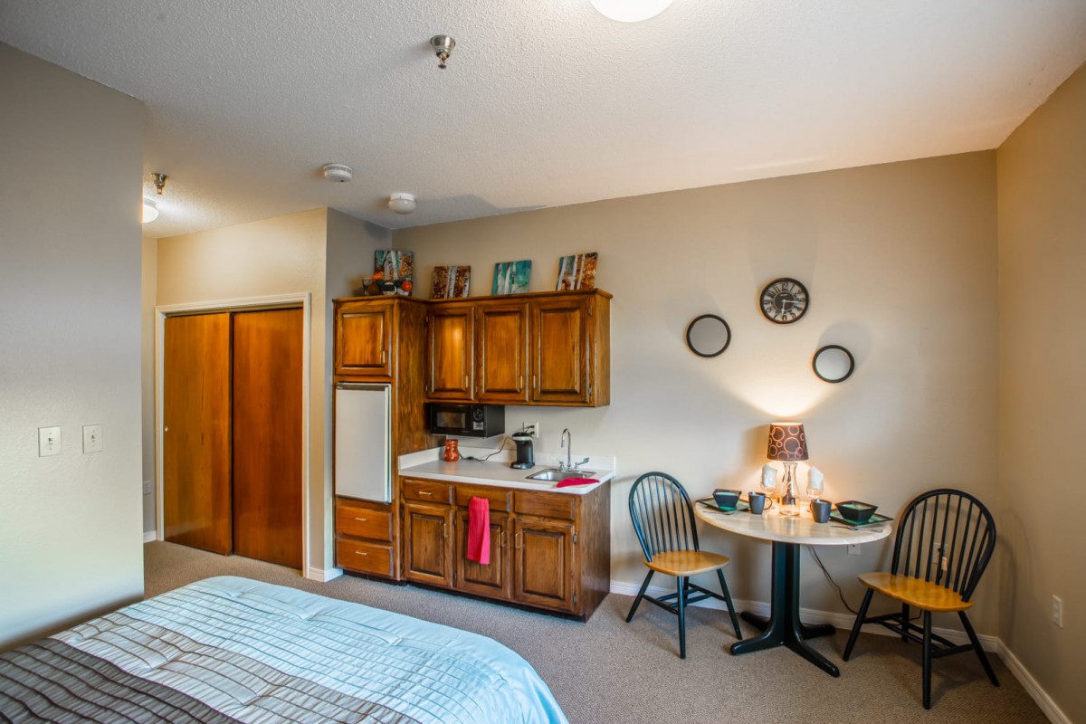 A cozy room with a kitchenette and a small dining area.