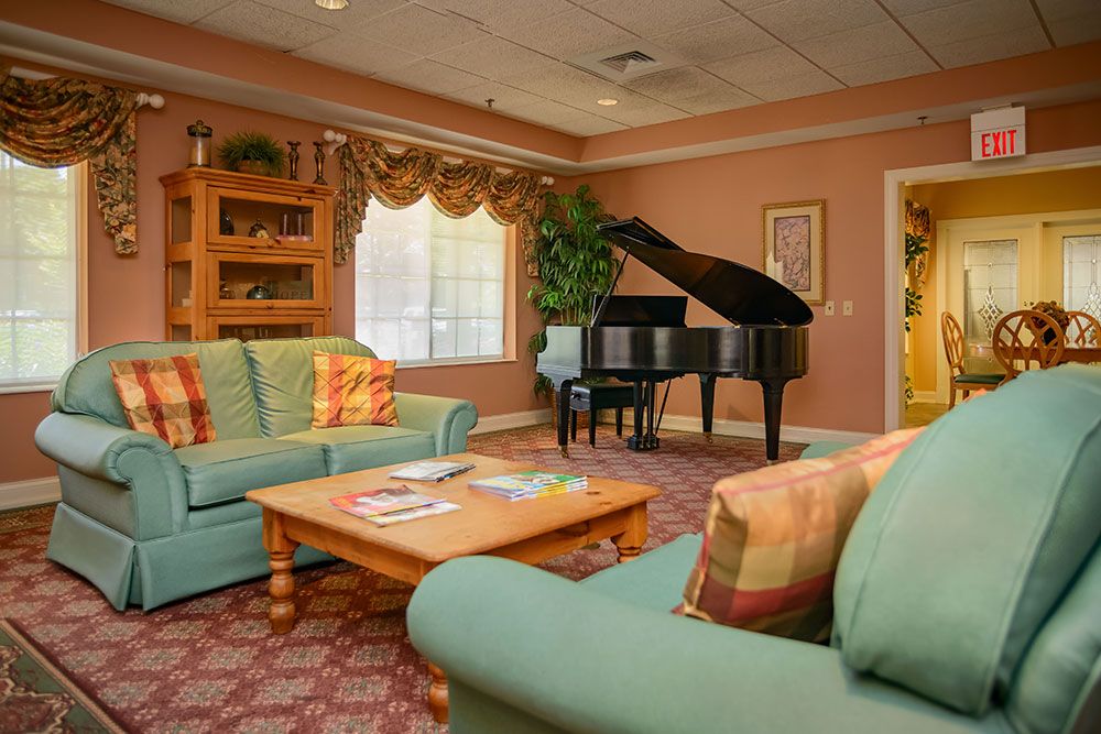 A cozy living room with a grand piano and comfortable seating.
