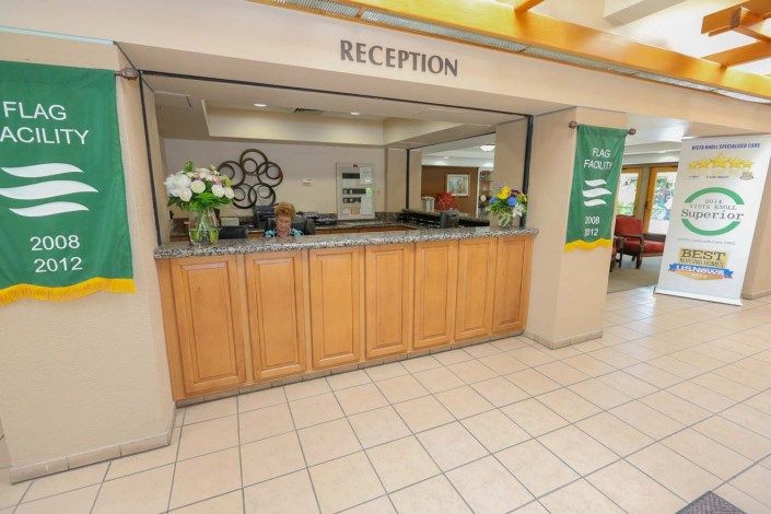 A welcoming hotel reception desk with floral decorations.