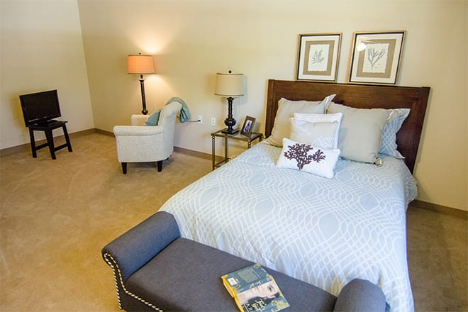 A cozy bedroom featuring a neatly made bed, stylish decor, and comfortable seating.