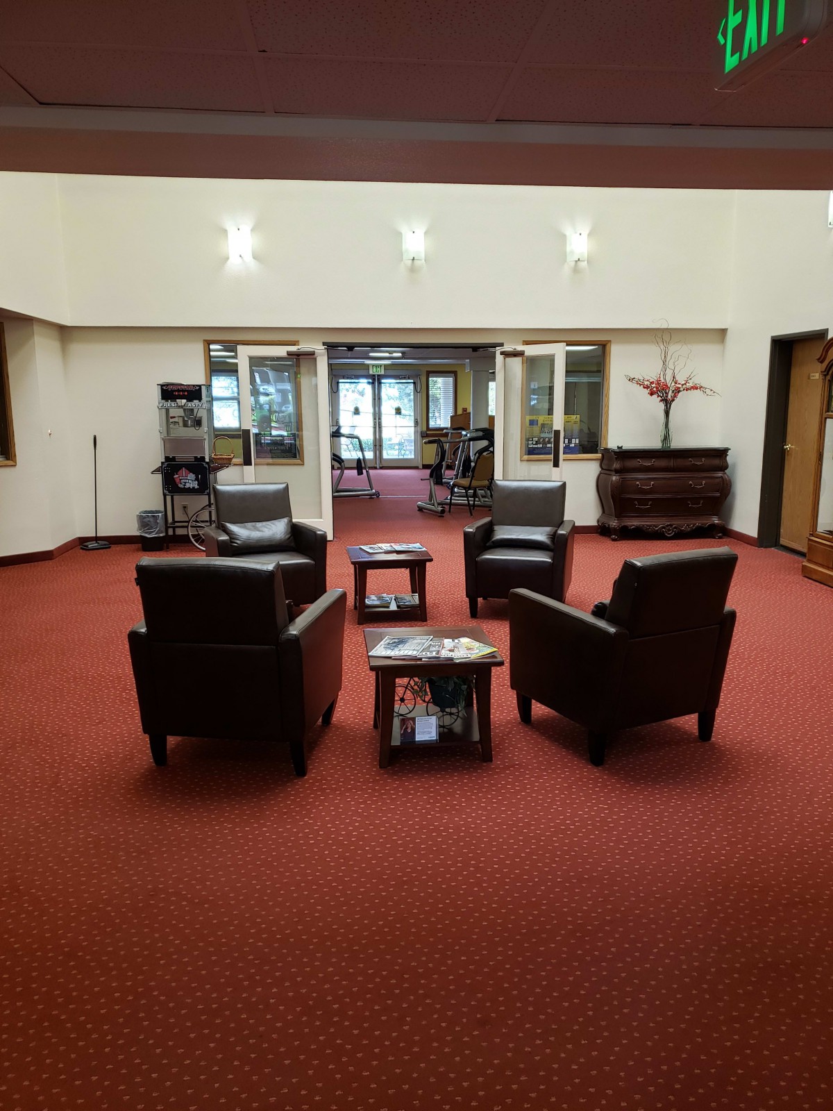 A spacious lobby with comfortable seating arranged in a circle on a red carpet.