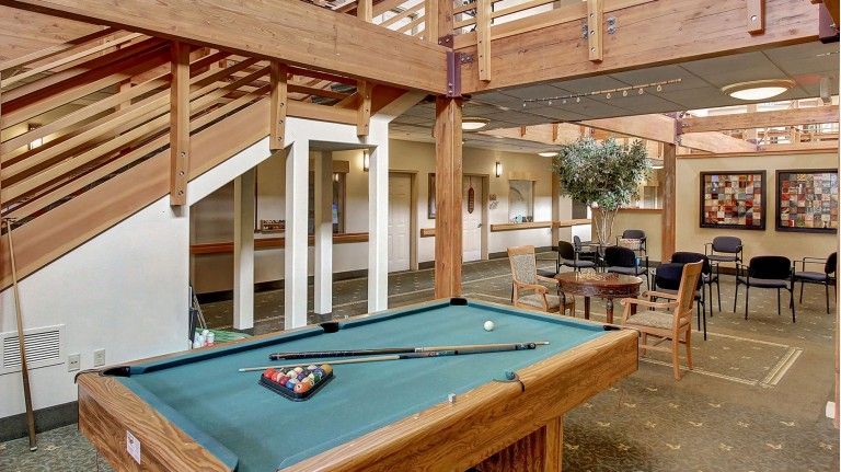A spacious recreation room featuring a pool table and comfortable seating.