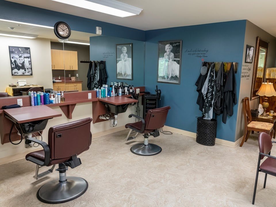 A tidy barbershop interior with chairs, mirrors, and hair styling products.