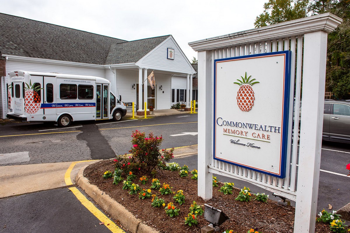 Entrance of a retirement home with a sign and transport vehicle.
