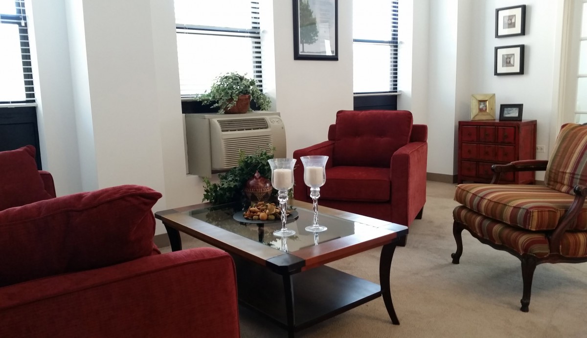 A cozy living room with red chairs and a decorative coffee table.