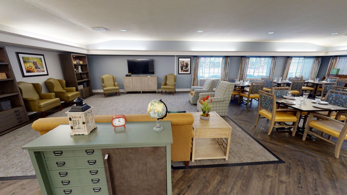 A cozy living room with comfortable seating, a television, and decorative items like a globe and lamp.