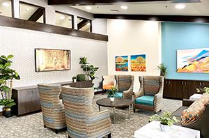 A modern lobby with comfortable seating, indoor plants, and colorful artwork.