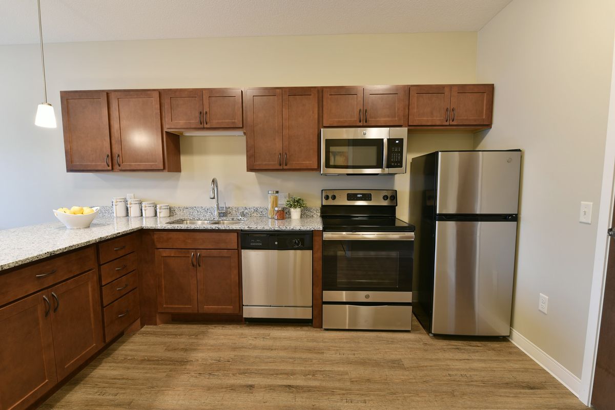 A modern kitchen with wooden cabinets and stainless steel appliances.