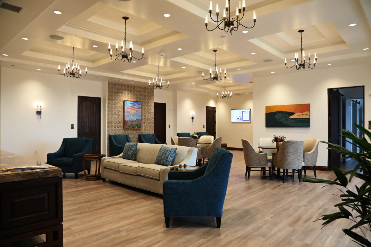 A spacious and elegant lounge area with plush seating and decorative chandeliers.