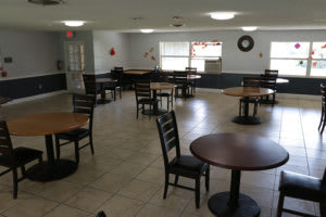 An empty cafeteria with several tables and chairs arranged neatly.