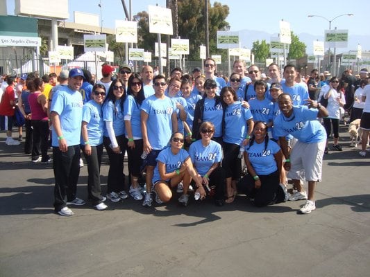A group of people wearing blue shirts, gathered outdoors at an event.