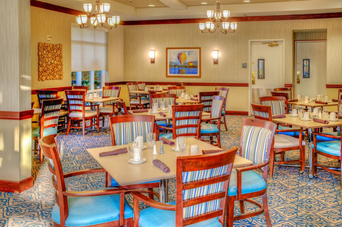 A well-lit dining area with neatly arranged tables and chairs.