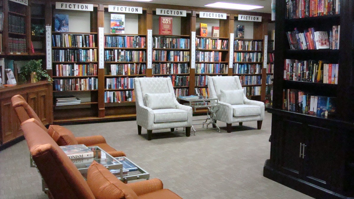 A cozy library reading area with bookshelves and comfortable chairs.