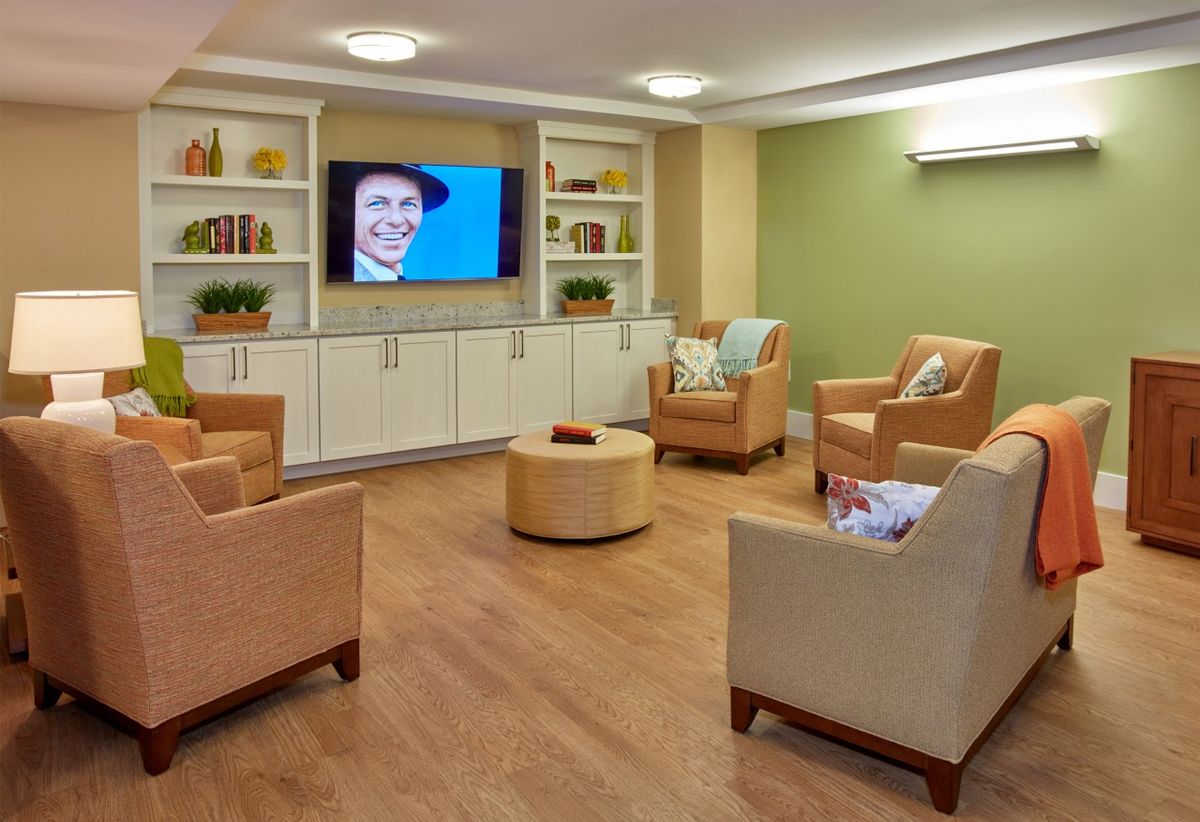 A cozy, modern living room with comfortable seating and a wall-mounted TV.
