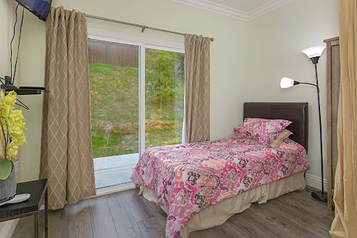 A cozy bedroom featuring floral bedding and sliding doors that open to a serene outdoor view.