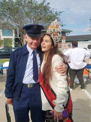 A cheerful moment at a community event, featuring a police officer and a participant in festive attire.