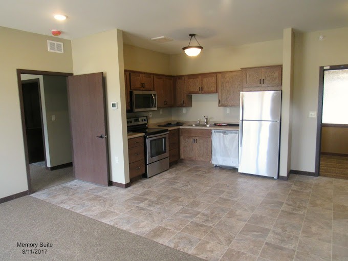 A modern apartment kitchen featuring stainless steel appliances and an open floor plan.