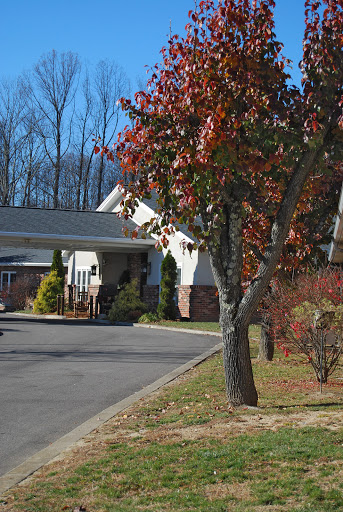 A serene view of a residential building surrounded by autumn foliage.