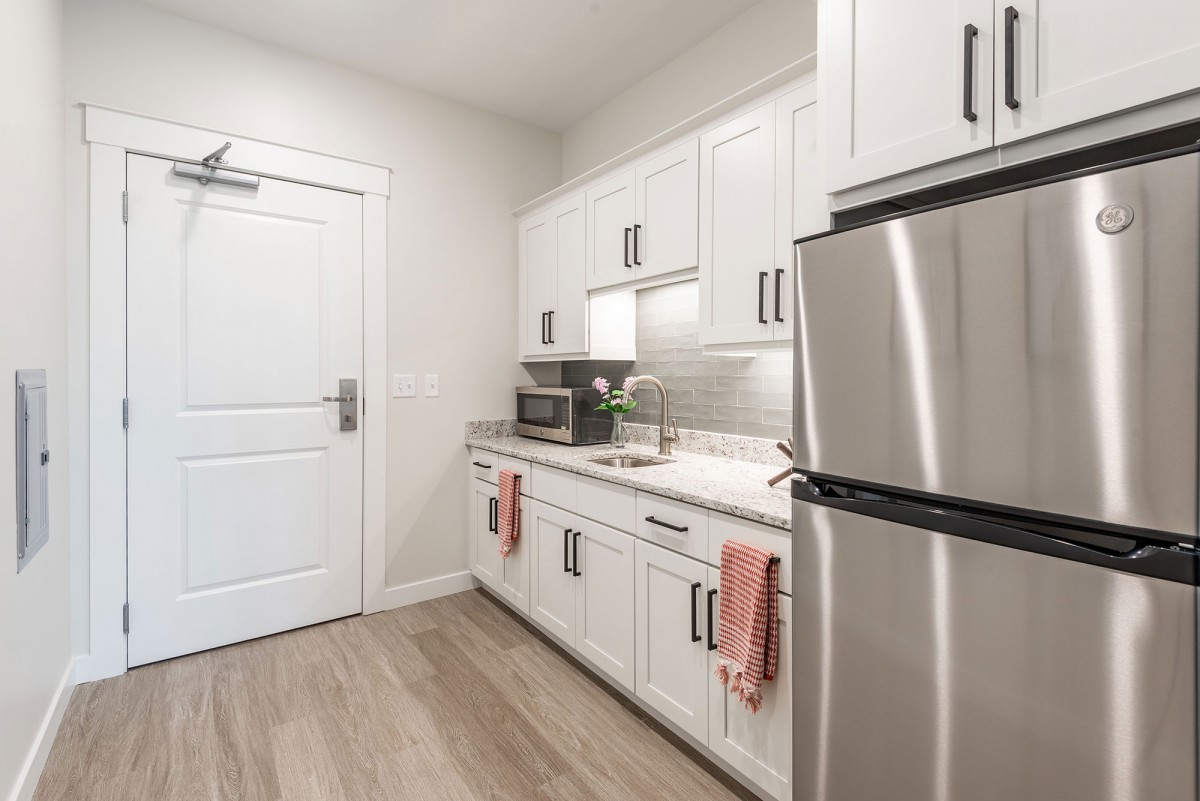 A modern kitchen with white cabinets and stainless steel appliances.