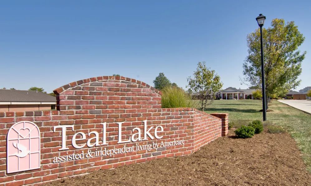 A brick sign marking the entrance to Teal Lake residential area.