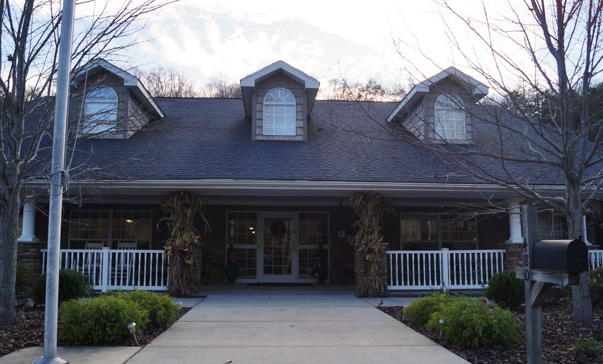 A two-story house with a porch and dormer windows.