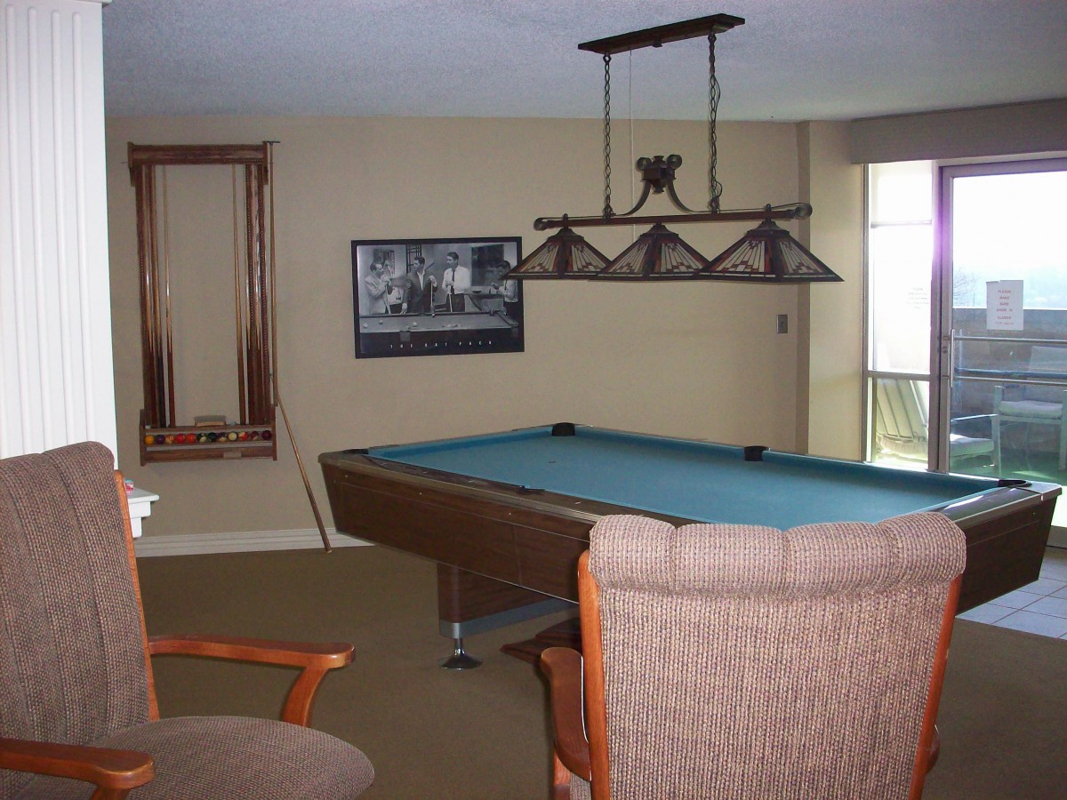 A cozy game room featuring a pool table and comfortable seating.