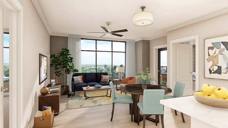 A modern living room with a cozy dining area, featuring large windows and natural lighting.