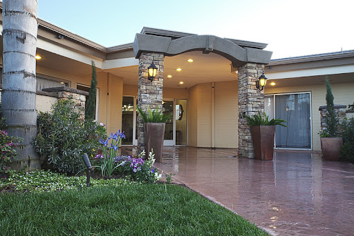 A beautifully designed entrance to a modern home, featuring elegant landscaping and warm lighting.