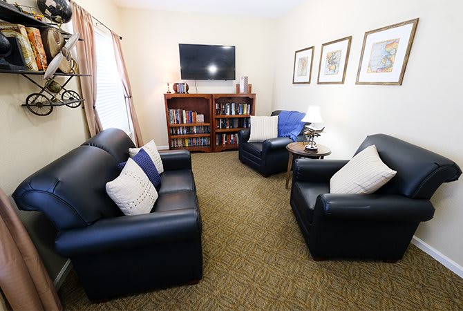 A cozy living room with leather seating and a TV.