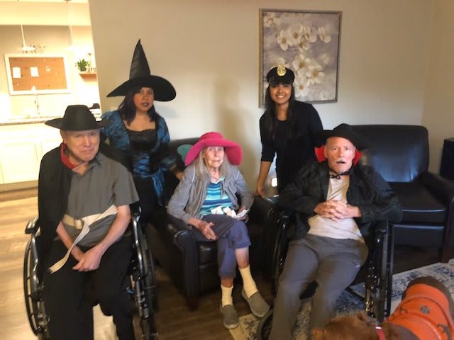 A group of people dressed in costumes, sitting together indoors.