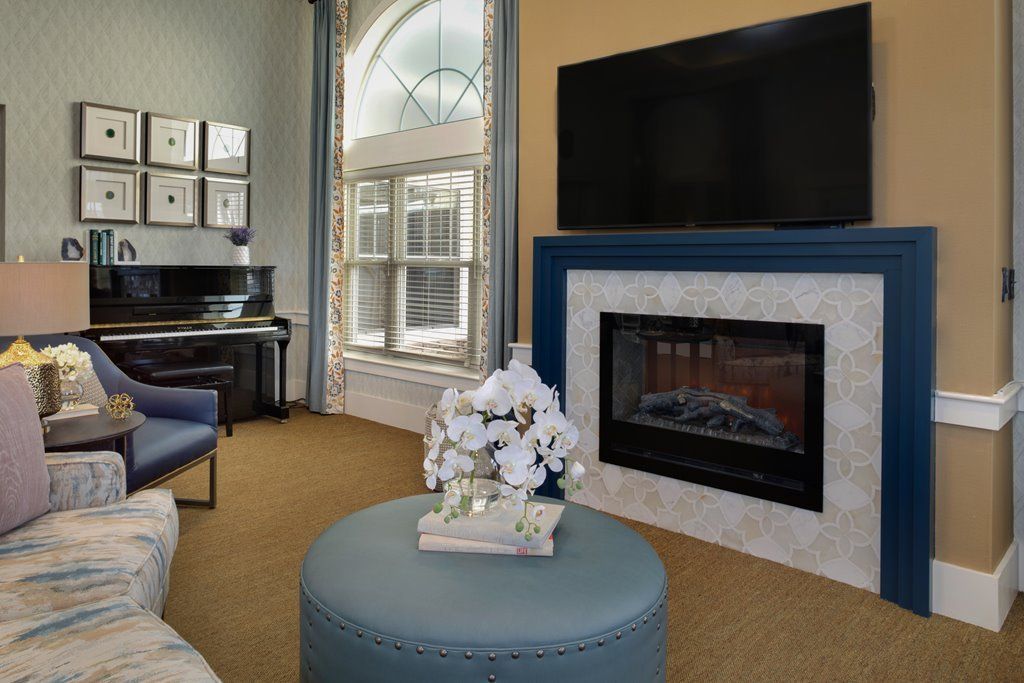 A cozy living room featuring a fireplace, piano, and television.
