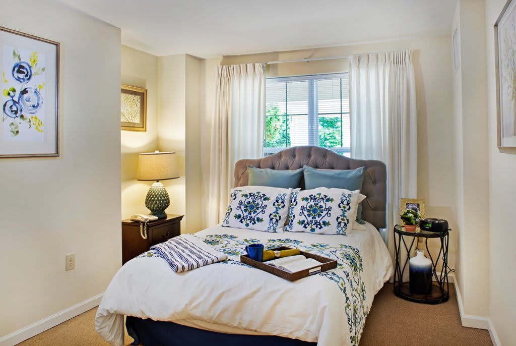 A cozy and well-decorated bedroom with a comfortable bed, decorative pillows, and bedside tables with lamps.