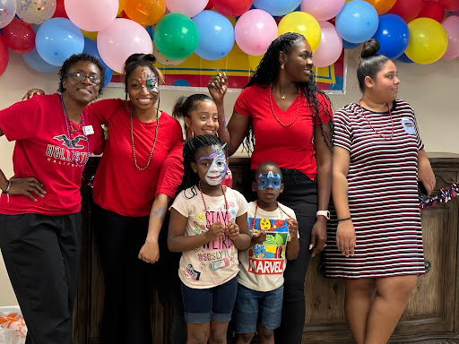 A joyful celebration with kids and adults enjoying face painting and colorful balloons.