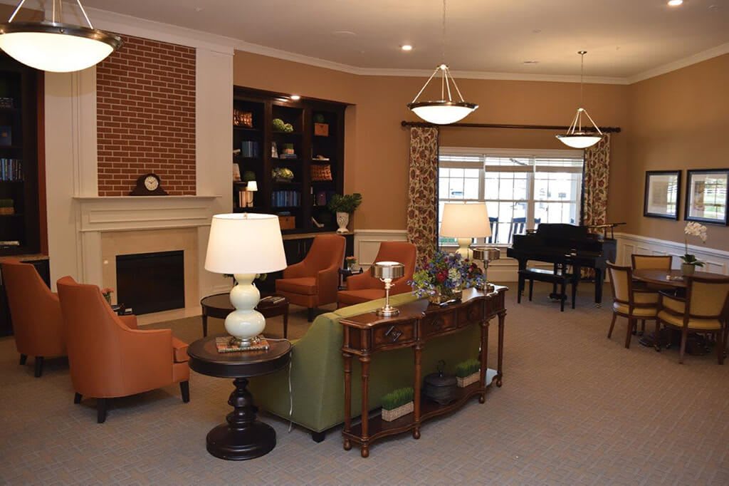 A cozy living room with a fireplace, bookshelves, and comfortable seating.