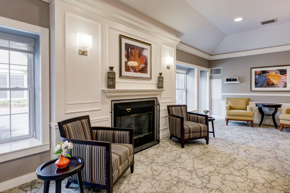 A cozy lobby area featuring a fireplace, elegant chairs, and modern decor.