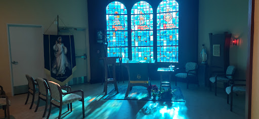 A serene church interior illuminated by colorful stained glass windows.