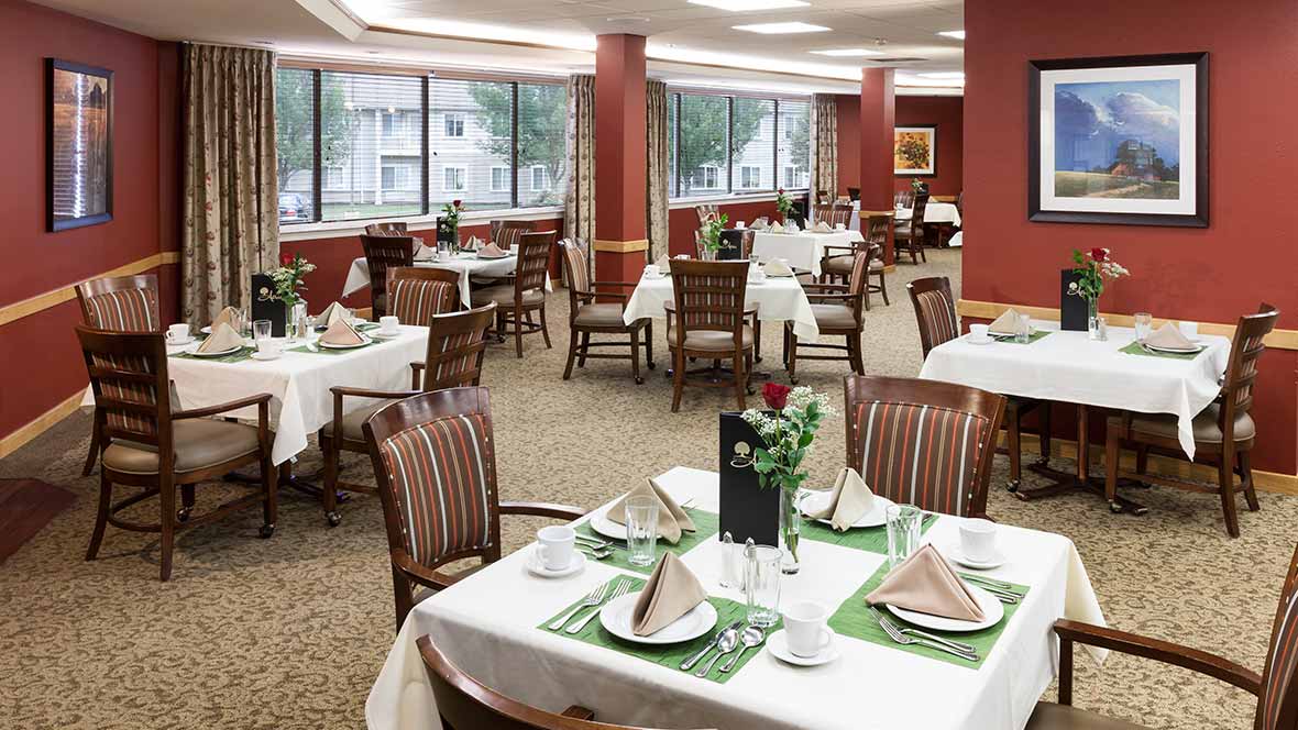 Elegant dining room with neatly set tables and comfortable chairs.