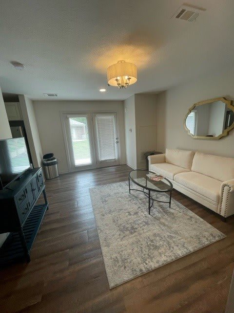A modern living room with a large sofa, flat-screen TV, and stylish decor.