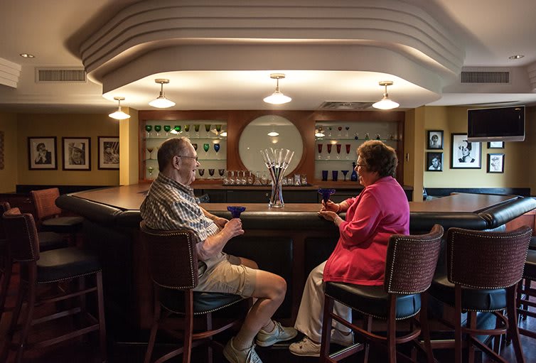 A couple enjoying drinks and conversation at a cozy bar.