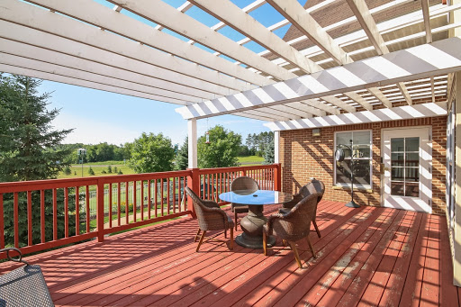 A sunny outdoor deck featuring a stylish pergola and comfortable seating for relaxation.