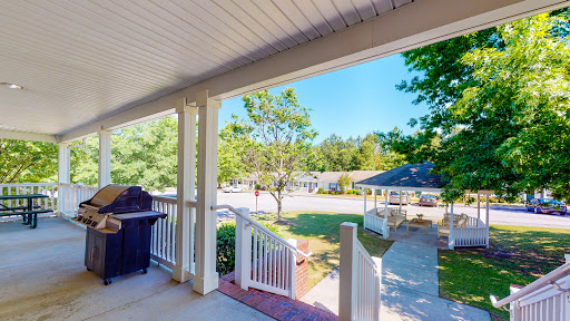A peaceful view from the porch, showcasing a sunny day and a vibrant garden.