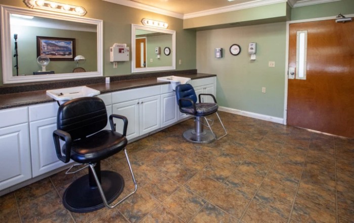 An interior view of a salon with chairs and mirrors.